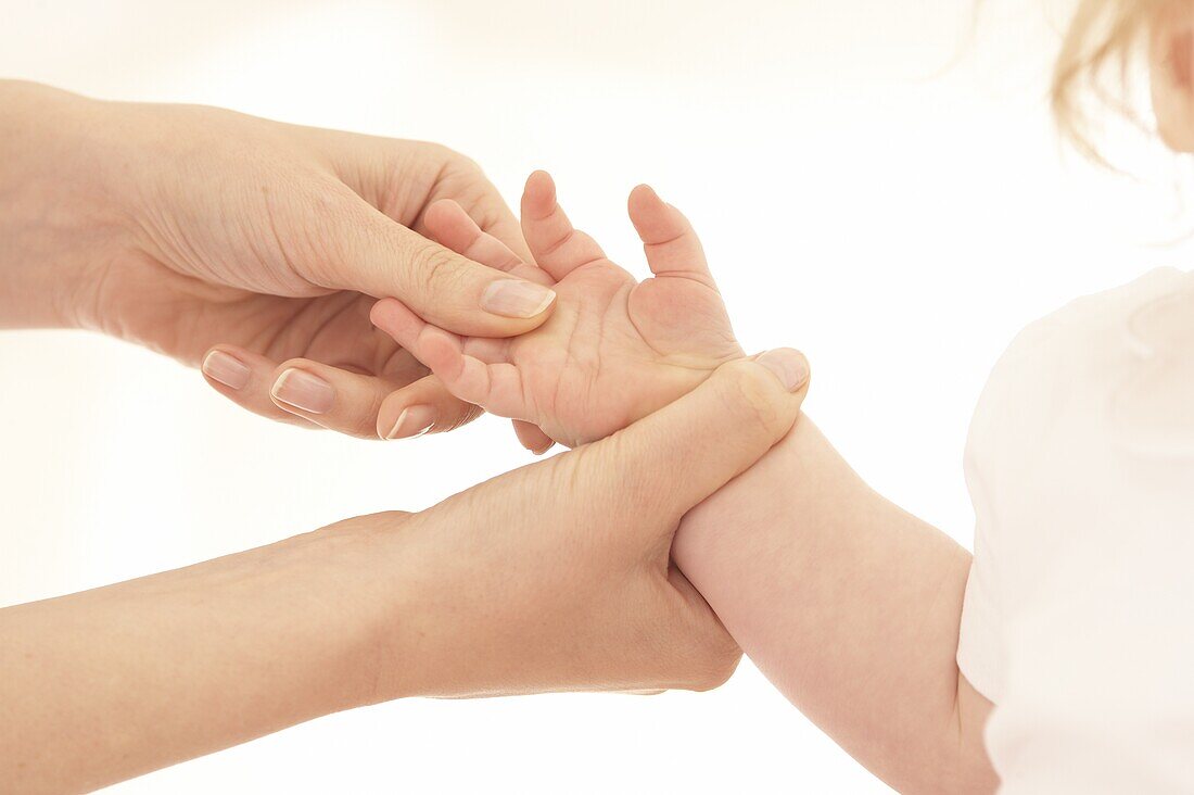 Pinching hand of baby to ease earache