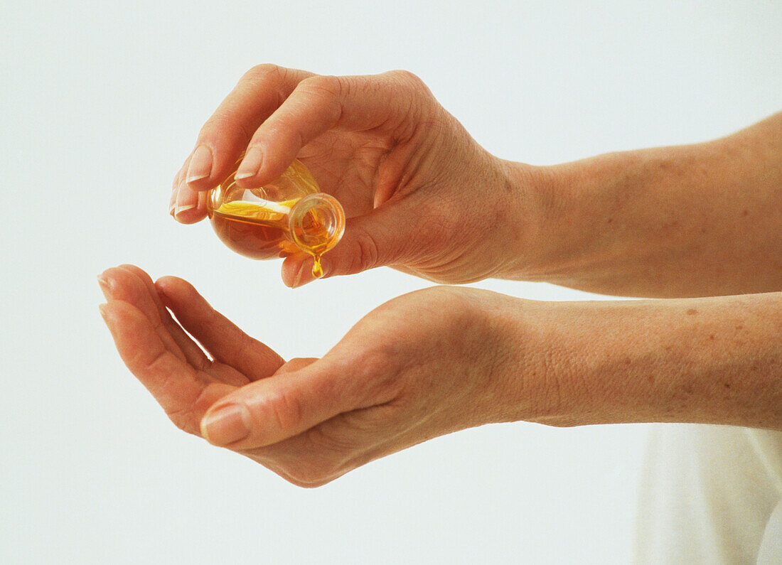 Oil being poured into palm from small bottle
