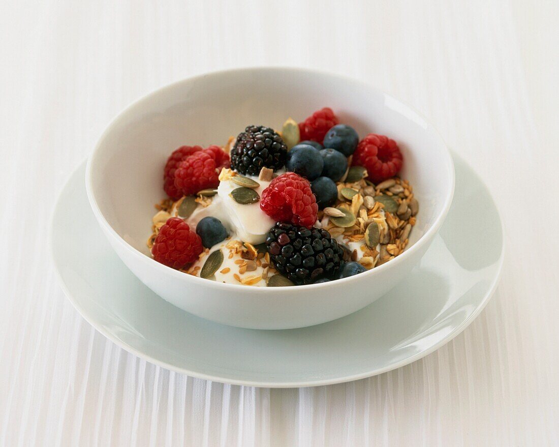Yoghurt, fresh berries and seeds in a bowl for breakfast