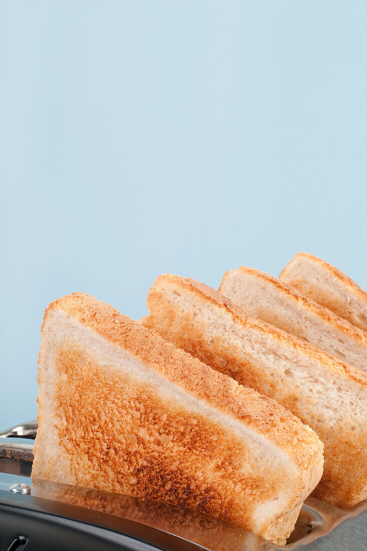 Four slices of toasted white bread in four-slot toaster