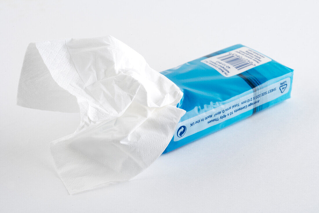 White facial tissue partially pulled from packaging