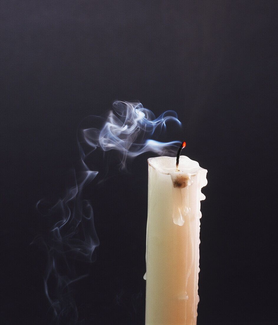 Smoke trailing from extinguished white candle