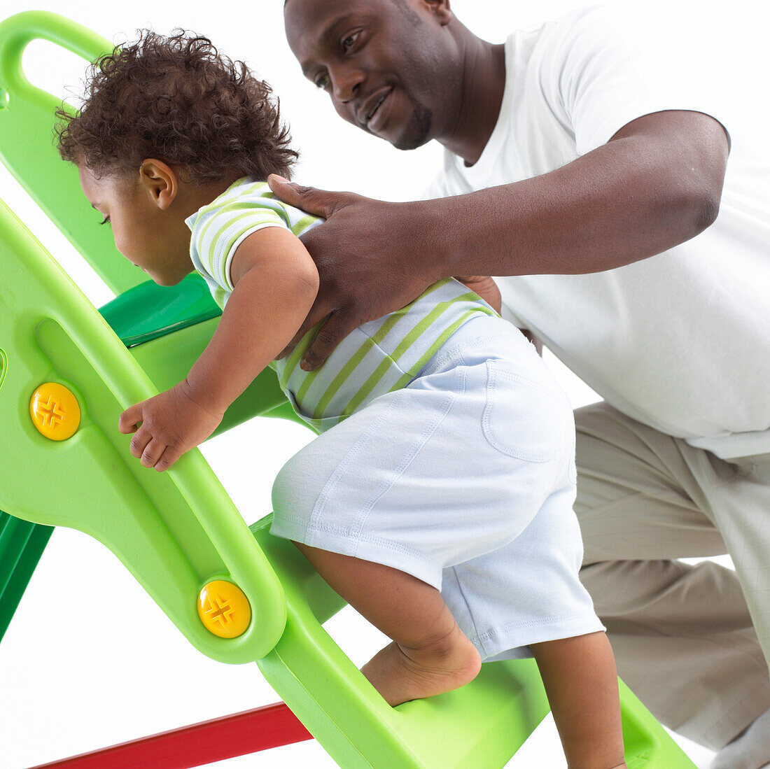 Father supporting toddler son climbing steps
