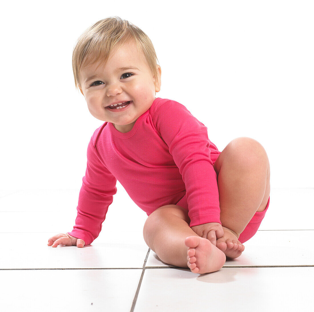 Baby girl sitting leaning on one hand