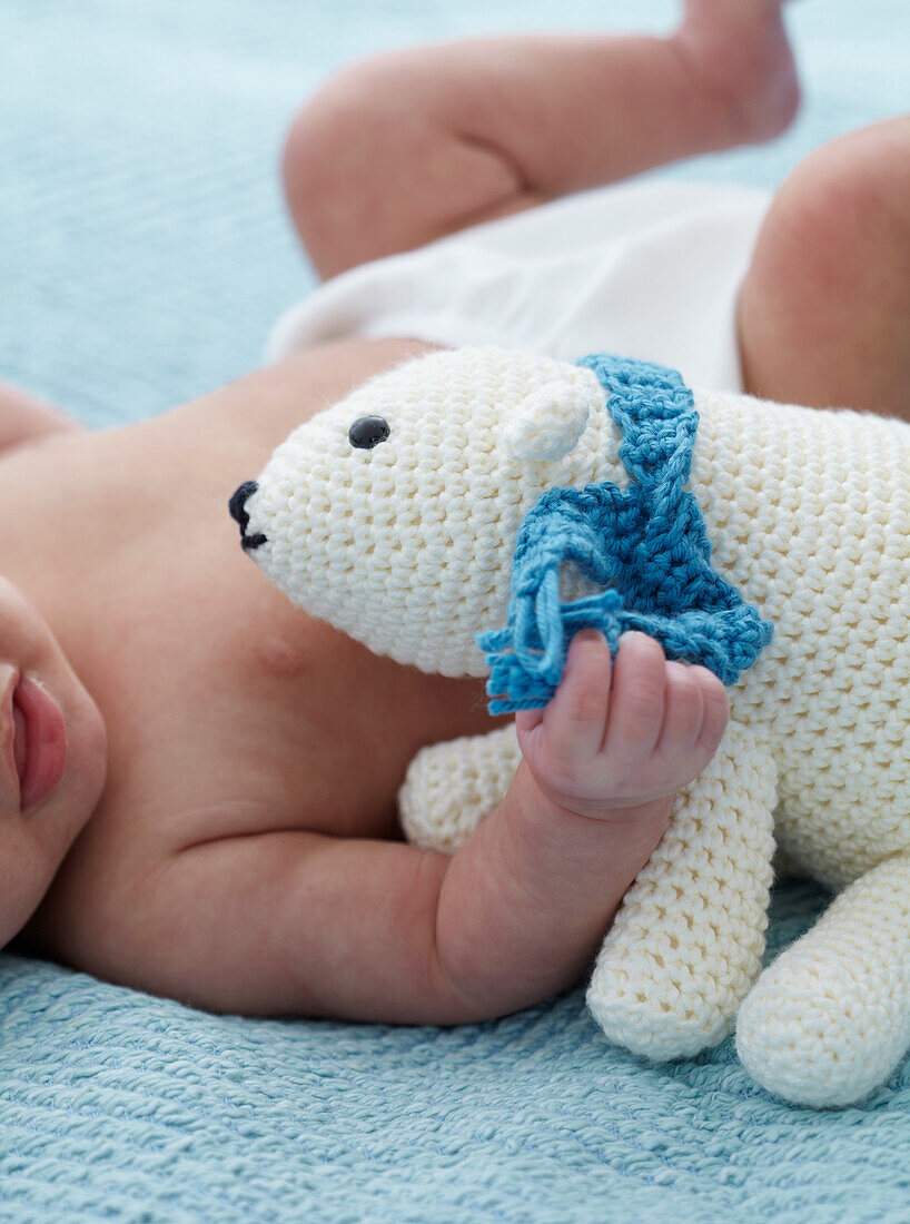 Baby girl cuddling crocheted polar bear
