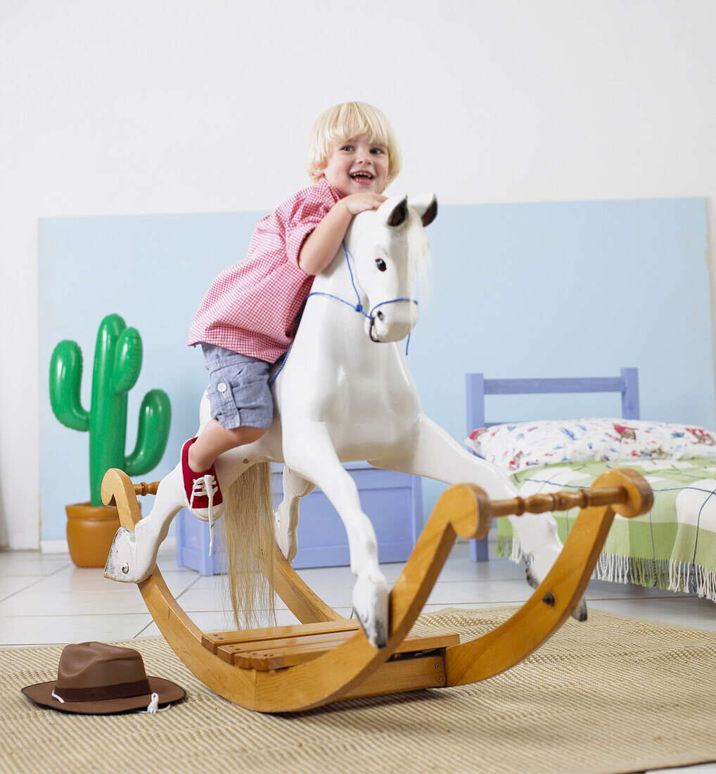 Boy mounting rocking horse