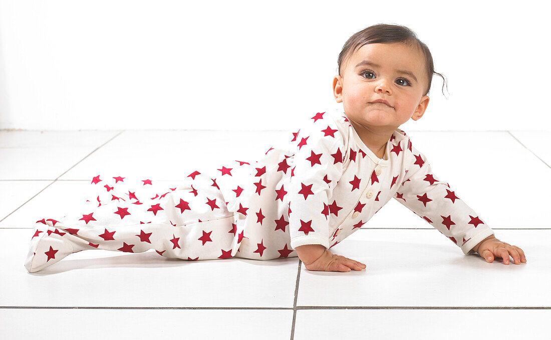 Girl wearing onesie lying on floor