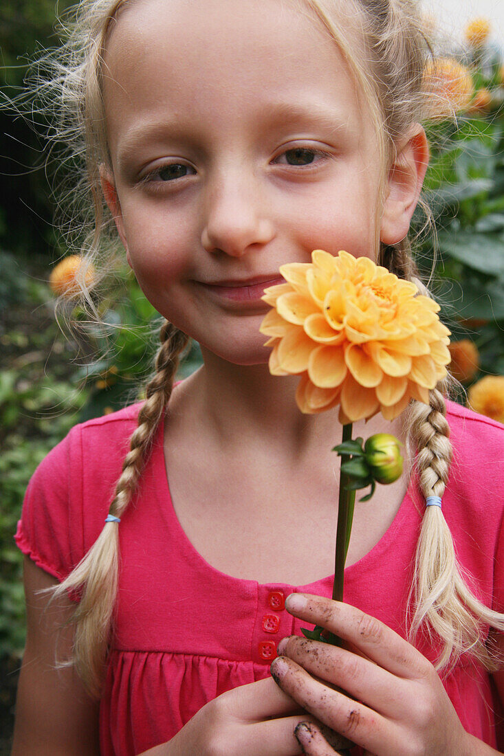 Girl holding an orange dahlia