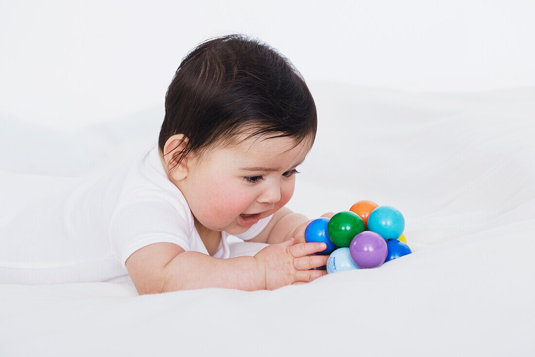 Baby girl playing with colourful balls