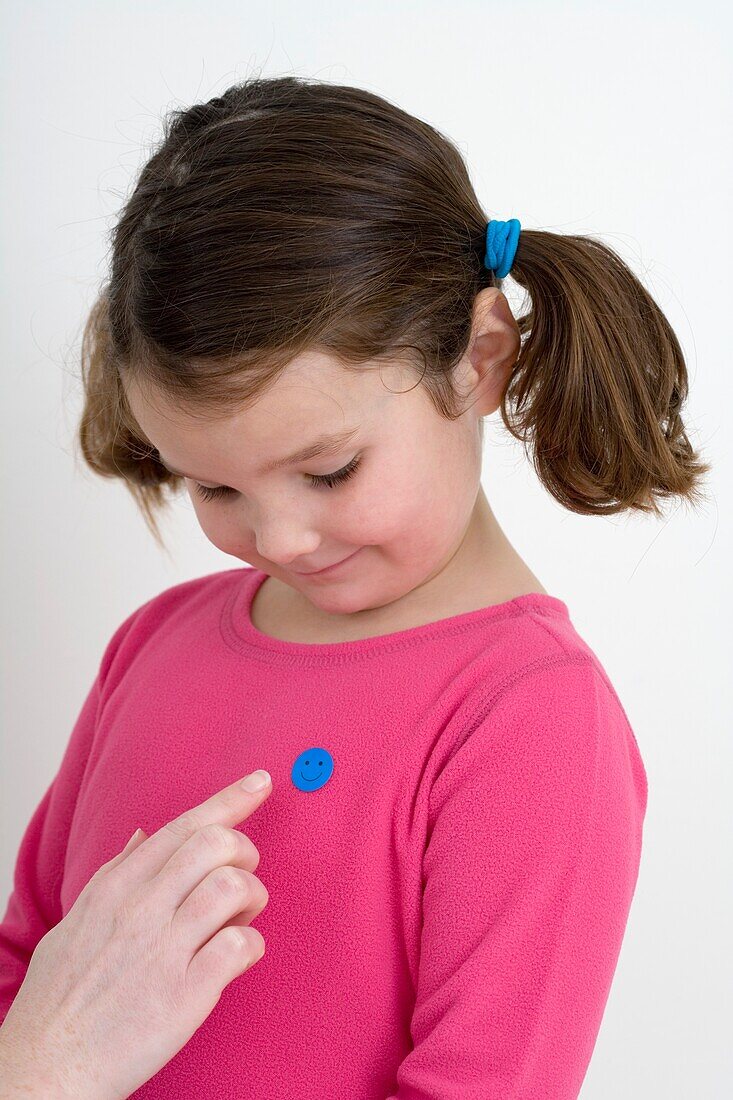 Woman's hand pointing to 'well done' sticker