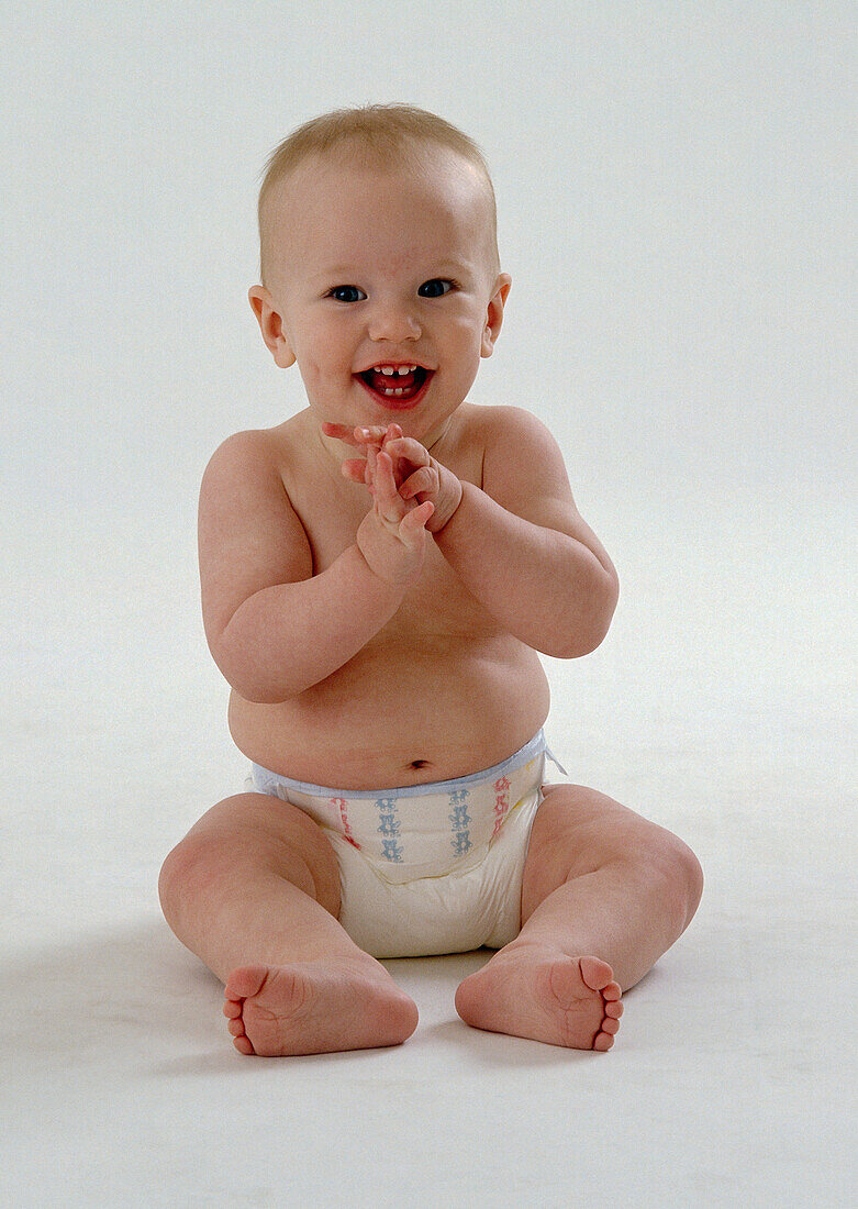 Smiling baby clapping hands together