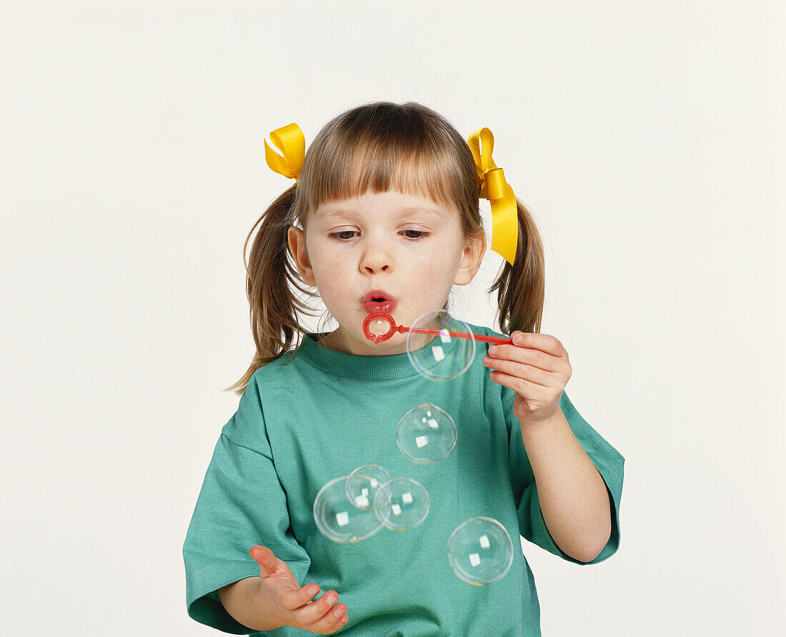 Girl blowing bubbles through wand