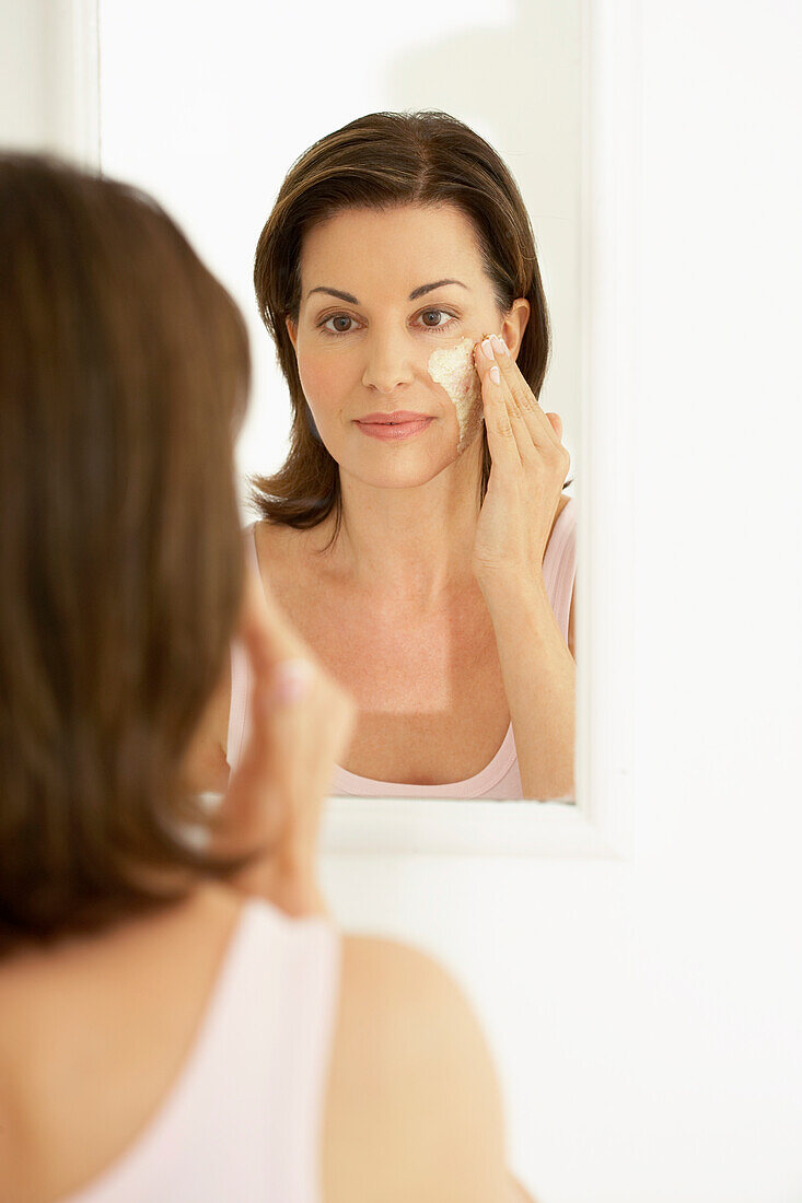 Woman applying face mask