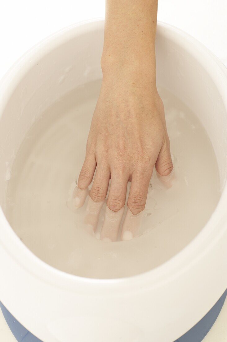 Immersing hand in paraffin-wax bath