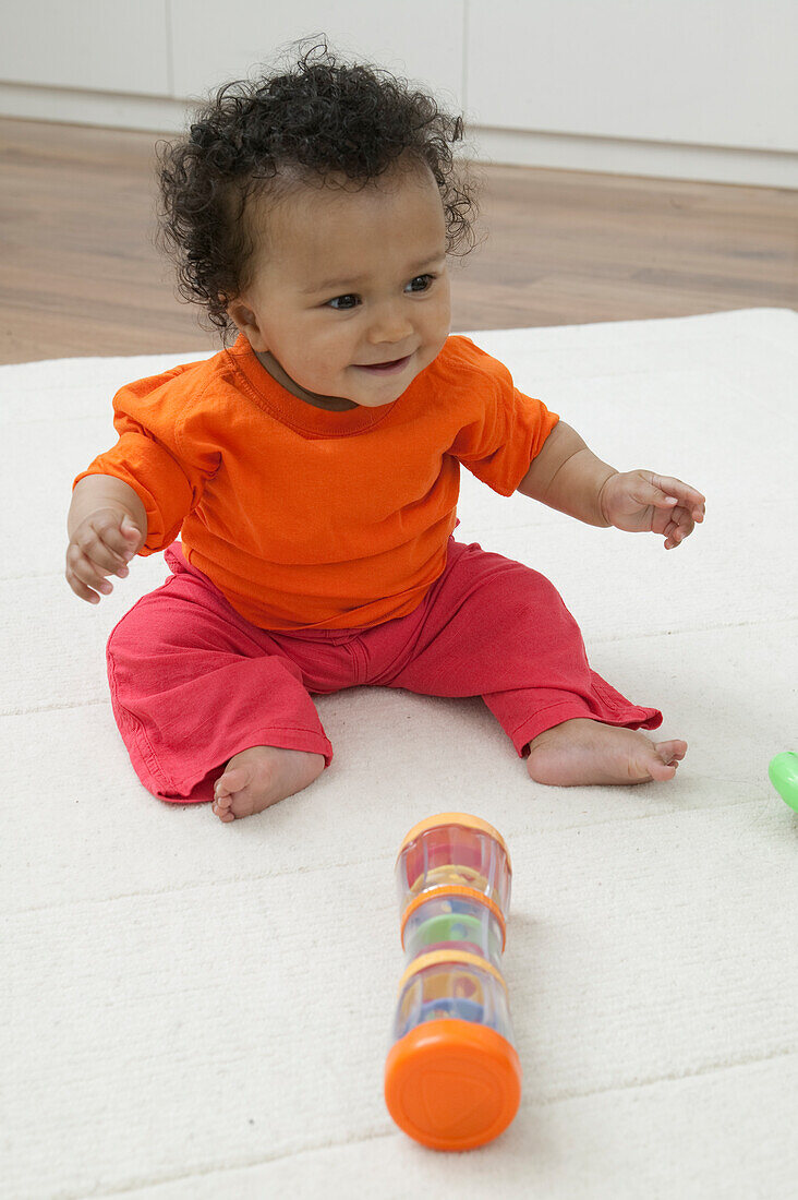 Baby girl playing with plastic toy