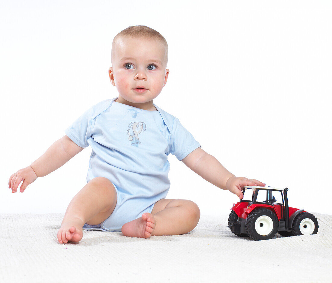 Baby boy playing with toy tractor