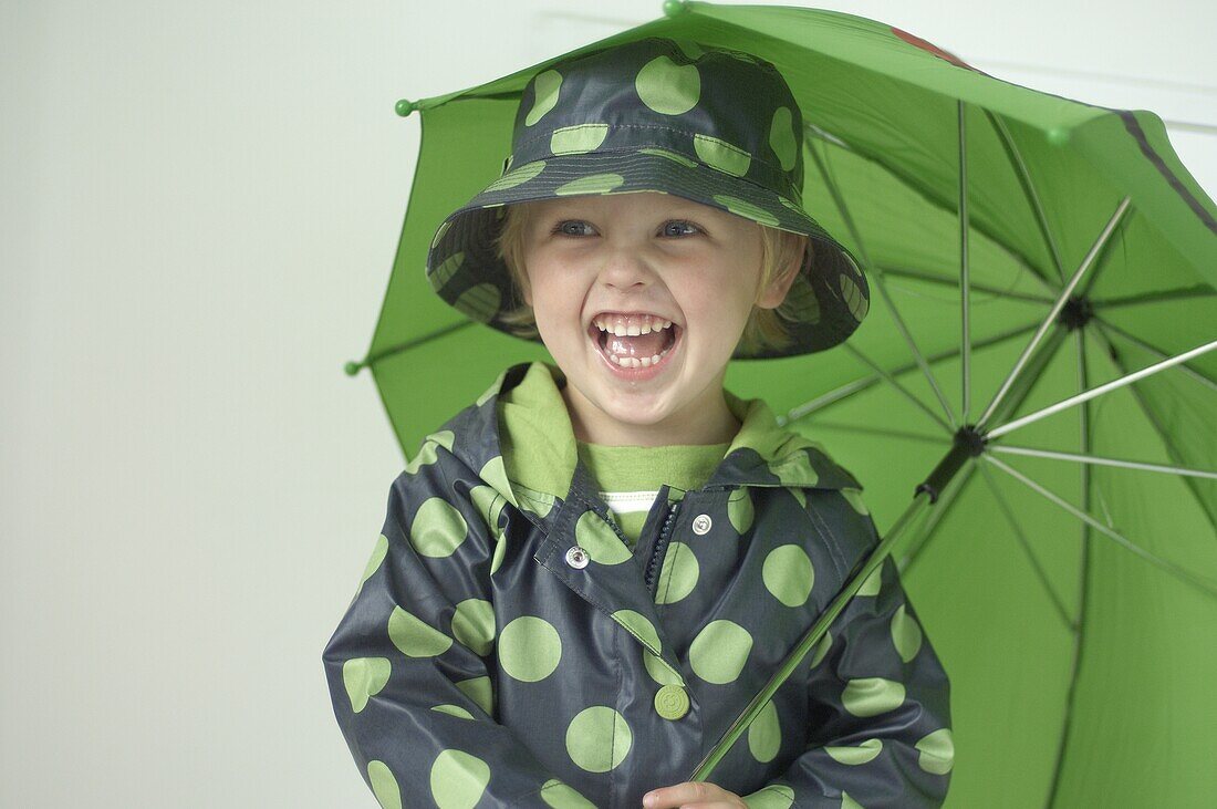 Boy wearing raincoat and holding umbrella