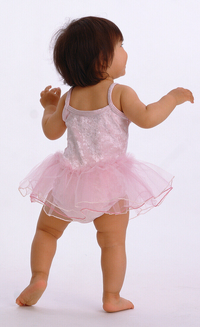 Barefoot toddler wearing pink ballerina tutu