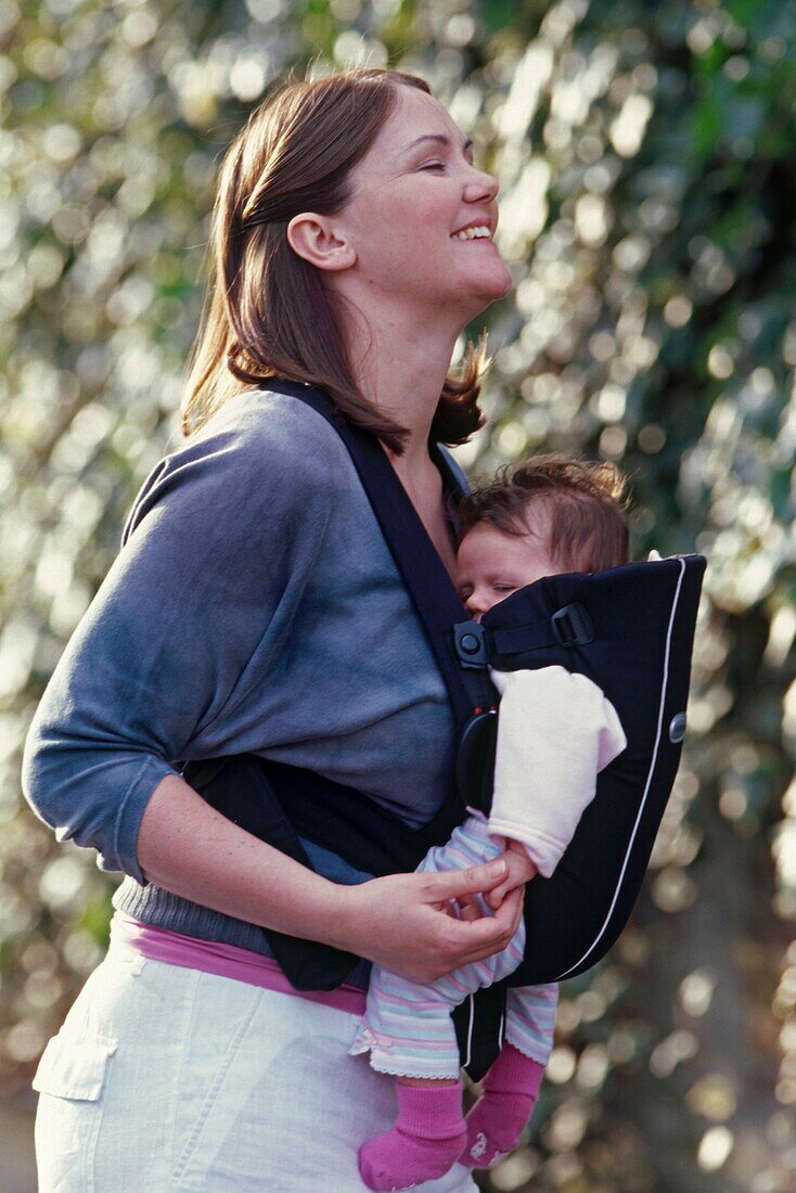 Woman carrying baby girl in a carrying sling