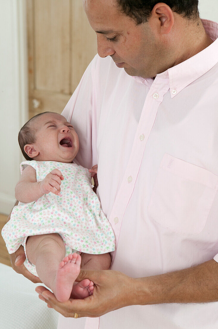 Man holding crying baby girl