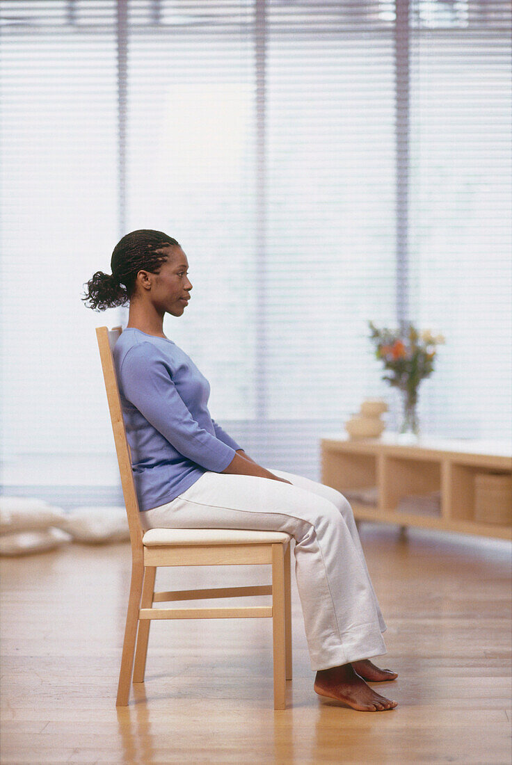 Woman sitting on wooden chair