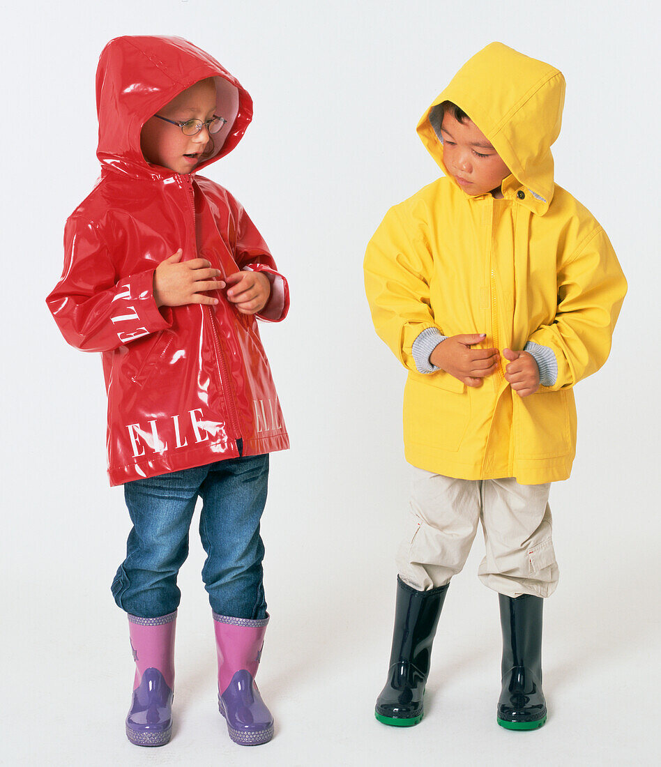 Boy and girl wearing raincoats and wellies