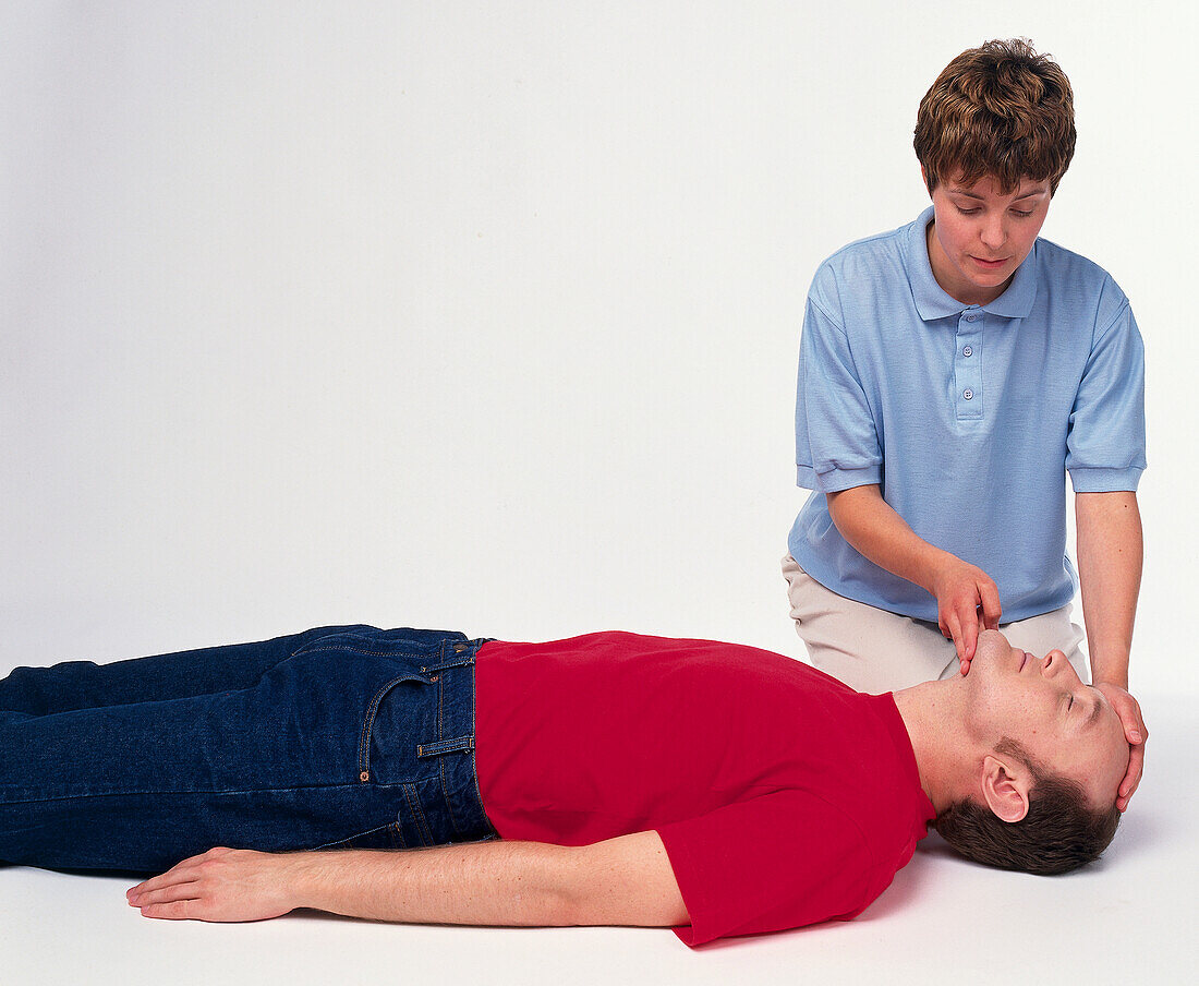 First aider checking casualty's breathing