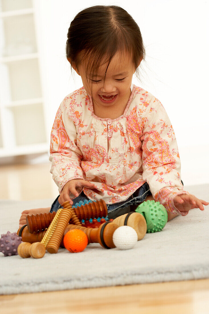 Girl playing with reflexology tools