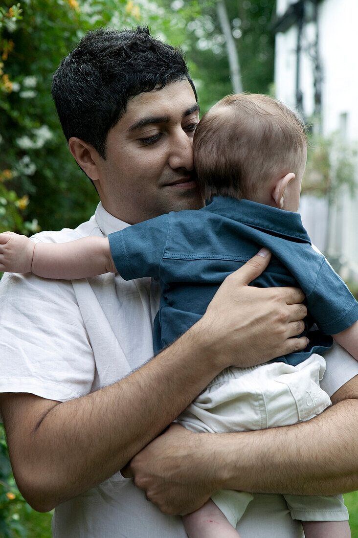 Young man holding baby boy