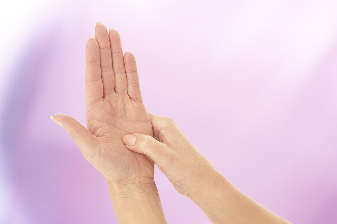 Pressing into palm of hand to ease pain in trunk of body