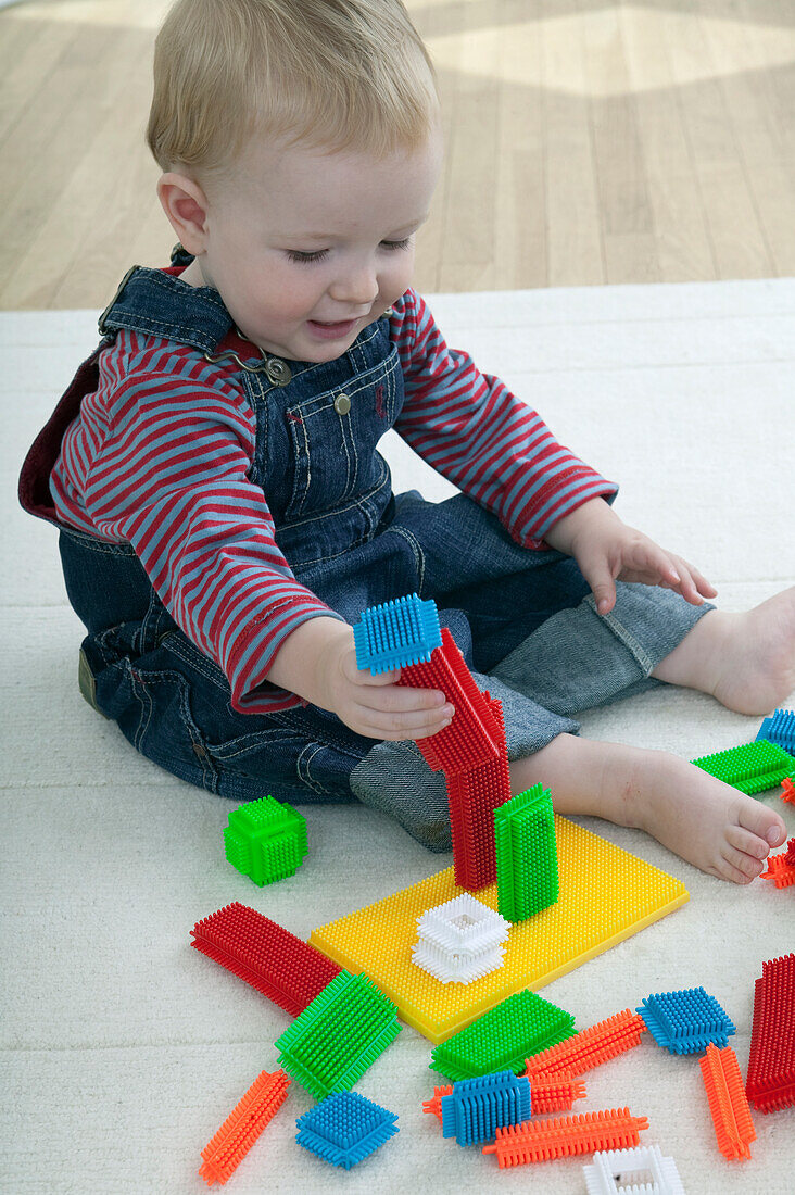 Baby boy playing with plastic building blocks