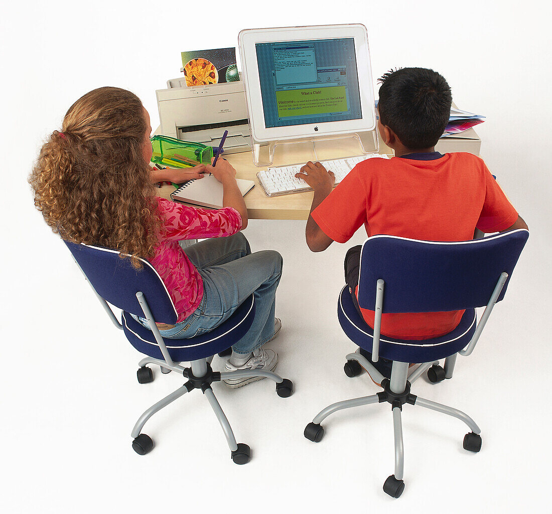 Girl and a boy sat at a computer workstation