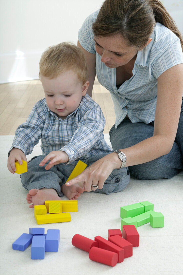 Woman and baby boy playing with building blocks