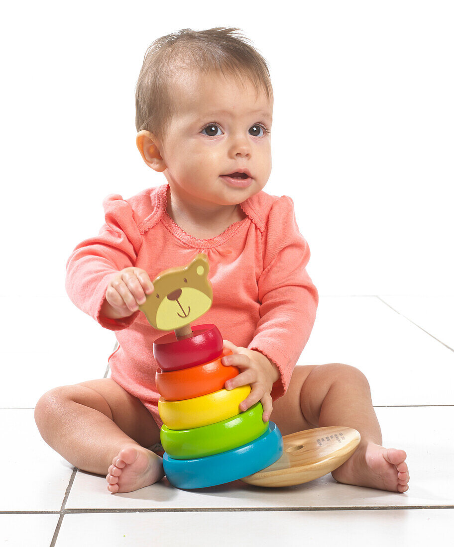 Baby girl playing with stackable ring toy