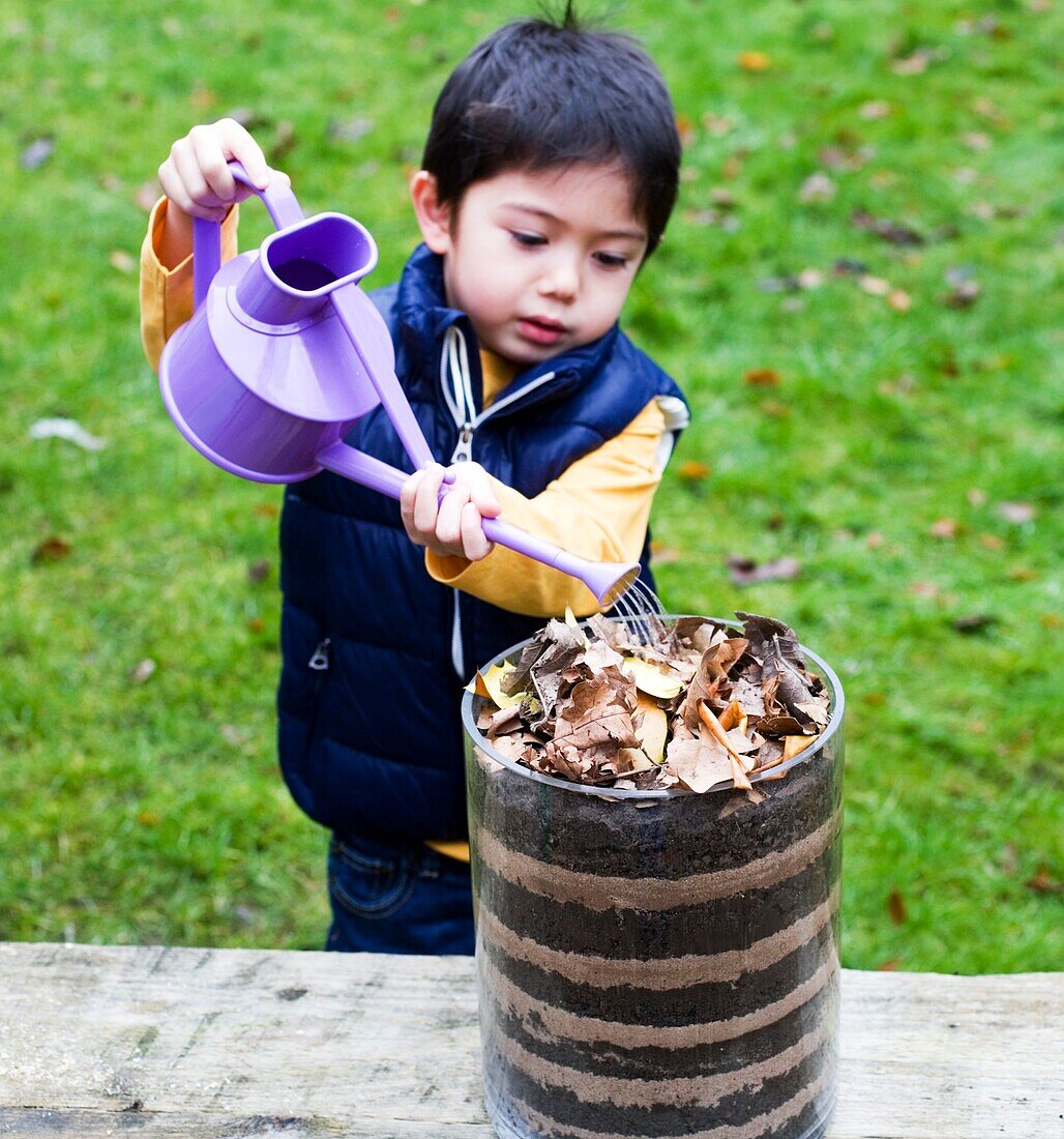 Boy watering a wormery