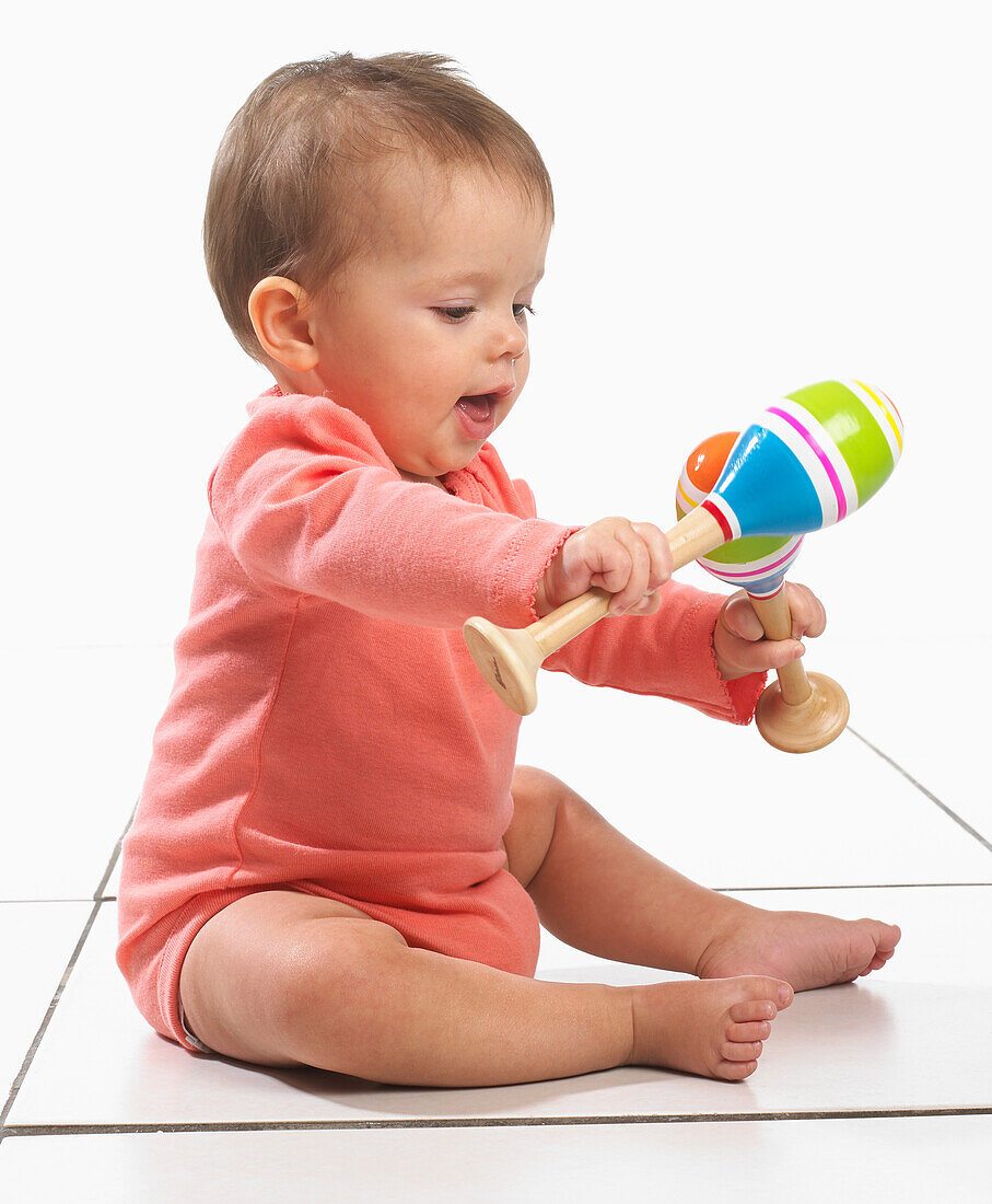 Baby girl playing with maracas