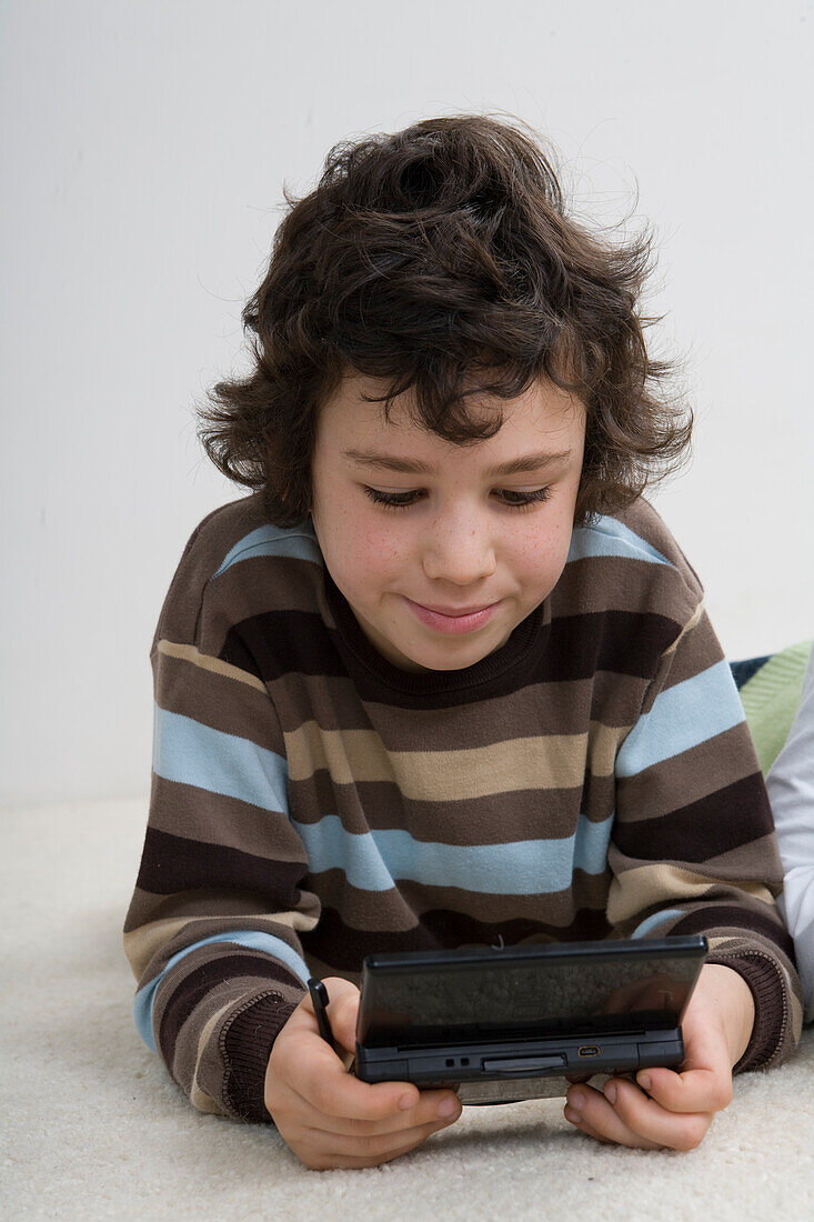 Boy holding hand-held gaming device