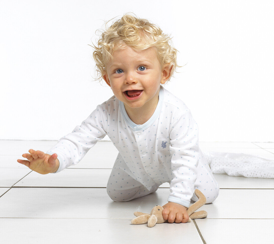 Boy wearing romper suit and crawling