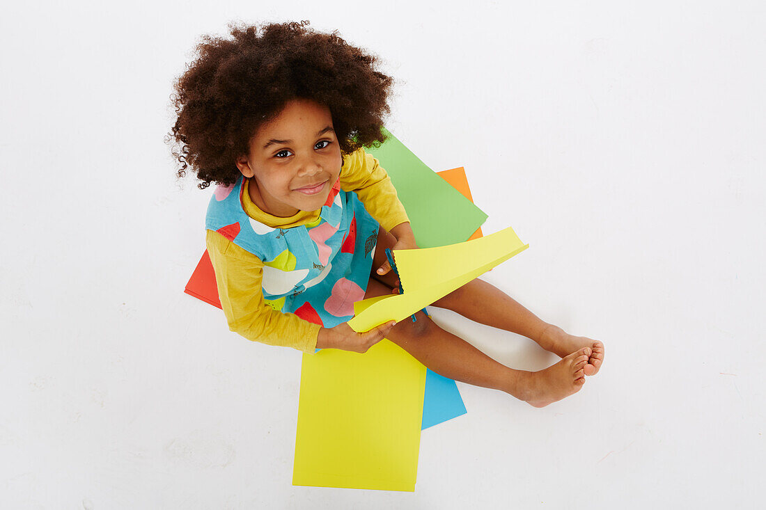 Little girl playing with craft paper