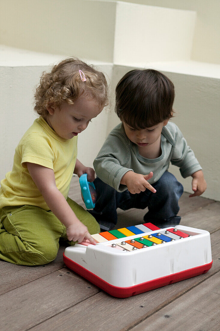 Boy and girl playing with toy musical instrument