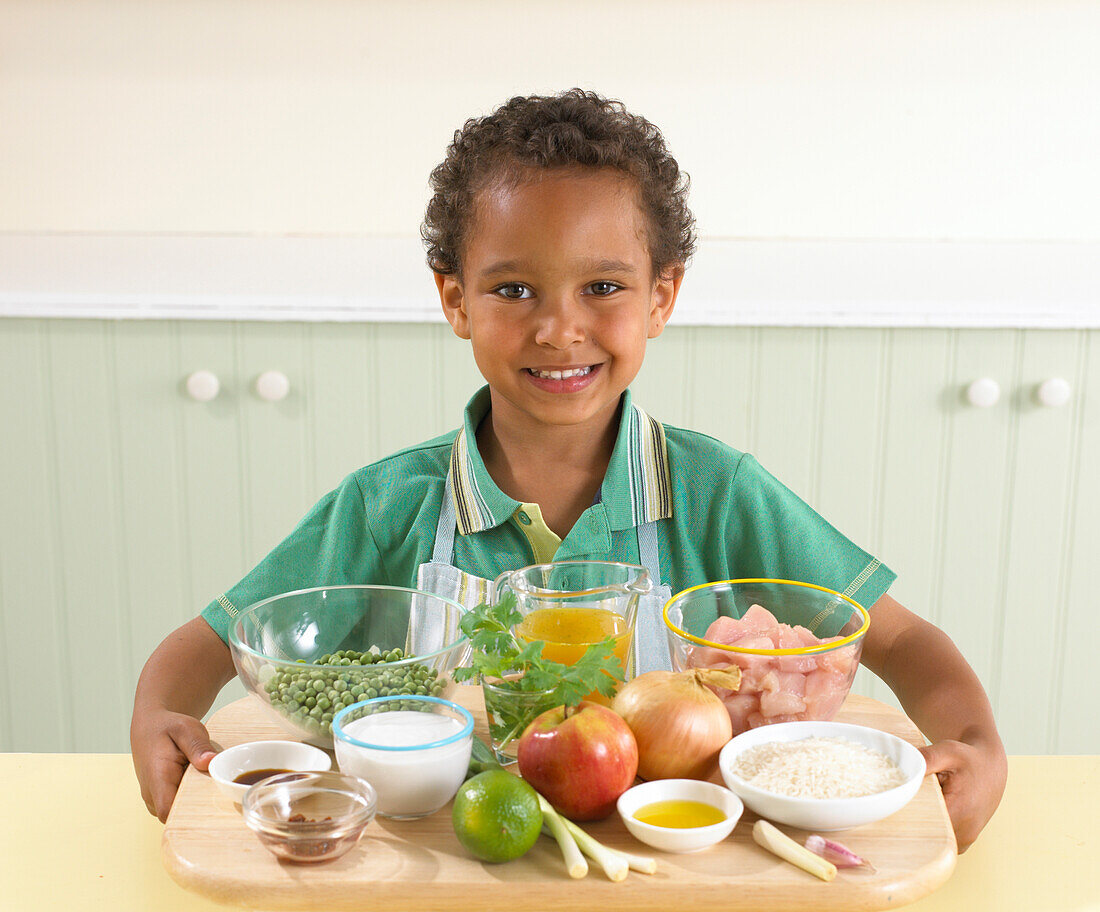 Boy holding the ingredients for apple and chicken curry