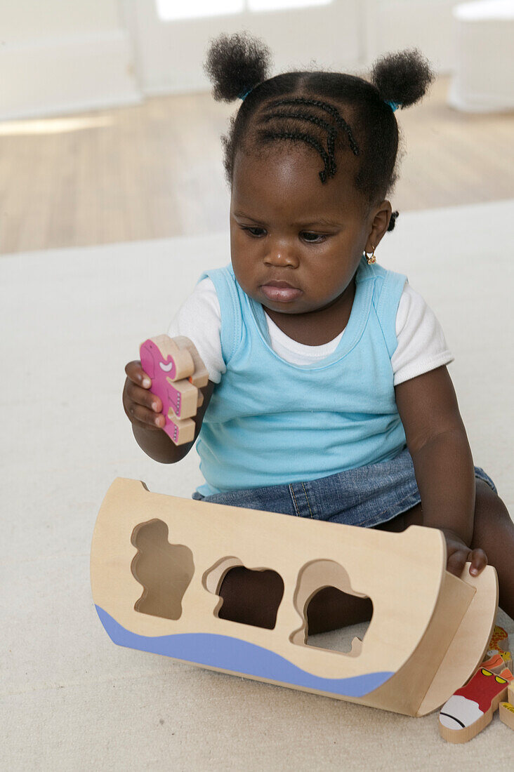 Baby girl playing with wooden toys