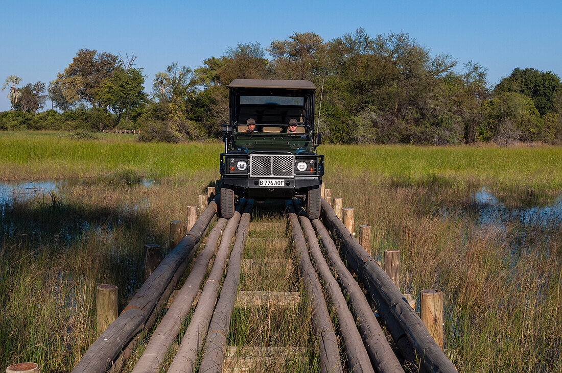 Safari vehicle crossing a log bridge