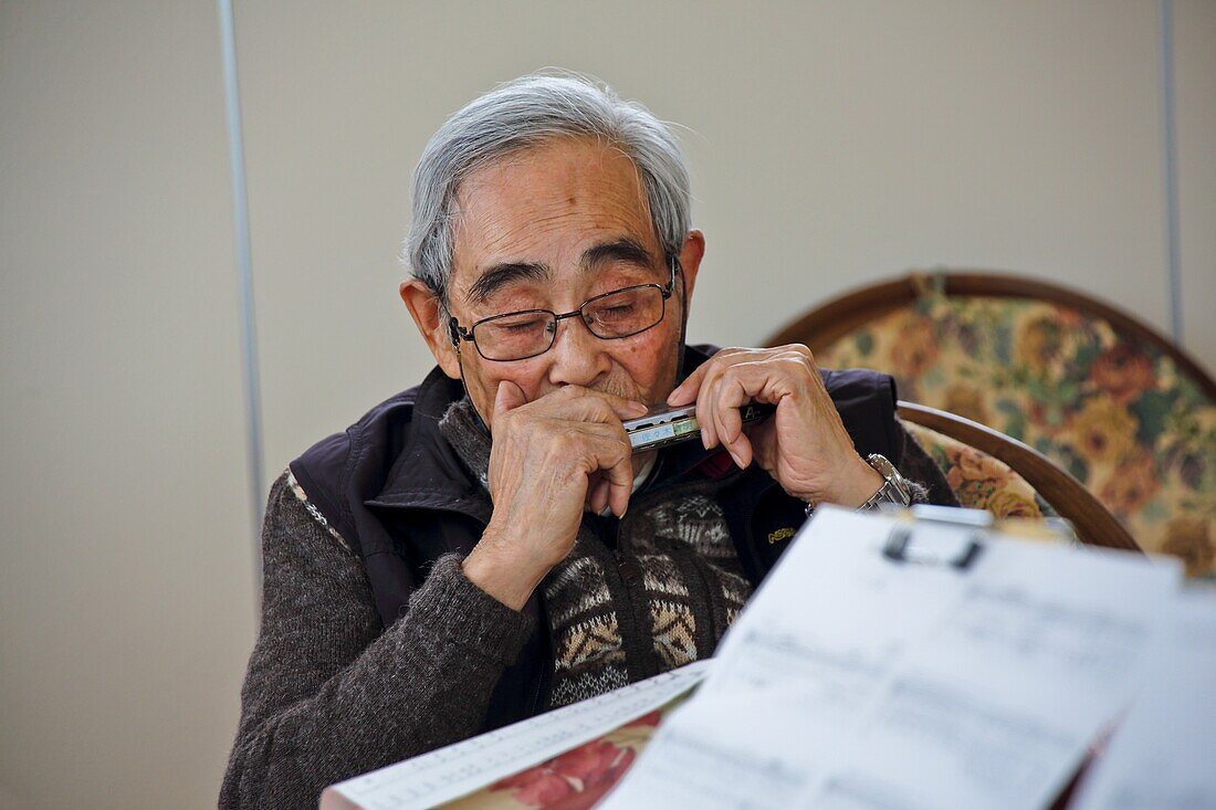 Elderly man playing harmonica, Fukushima, Japan