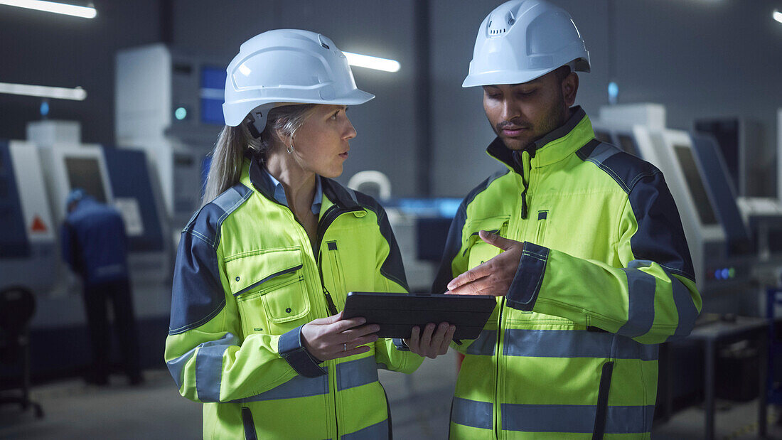 Engineer and manager talking and using a digital tablet