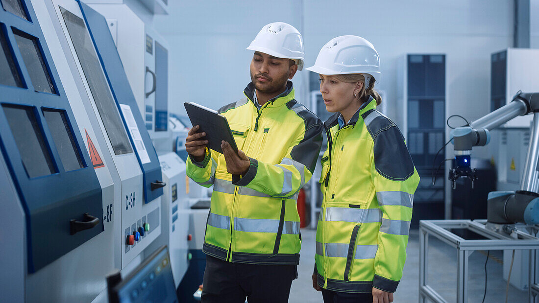 Engineer and manager talking and using a digital tablet