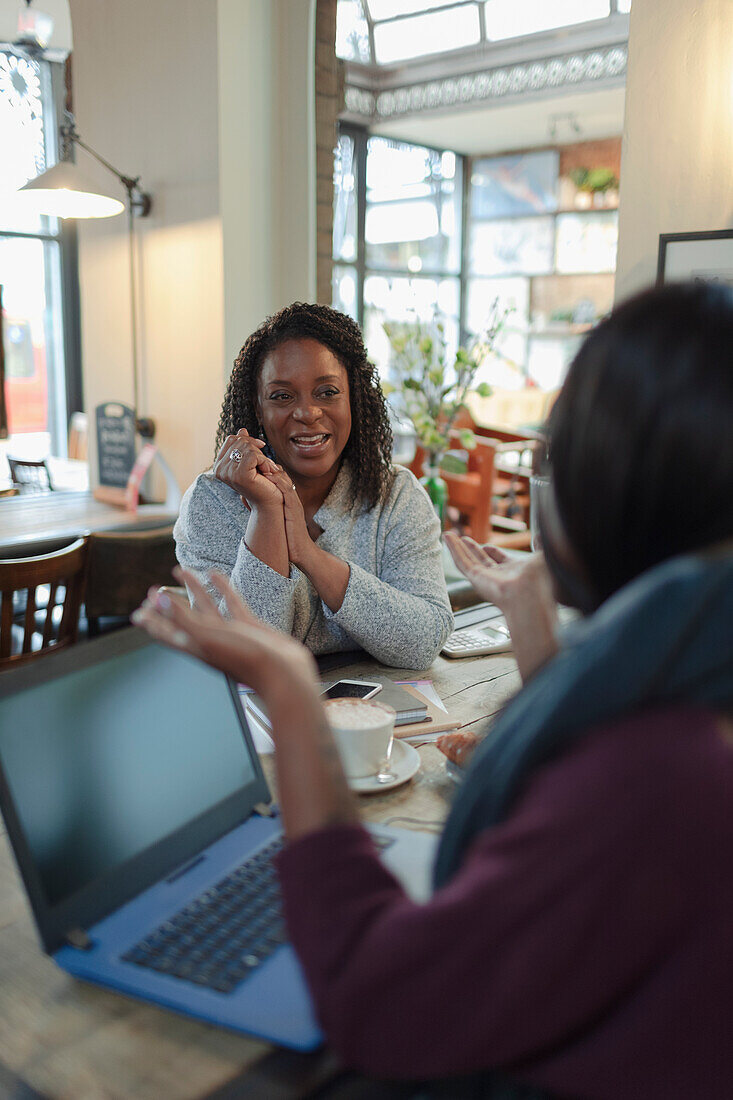 Mother and daughter talking in cafe