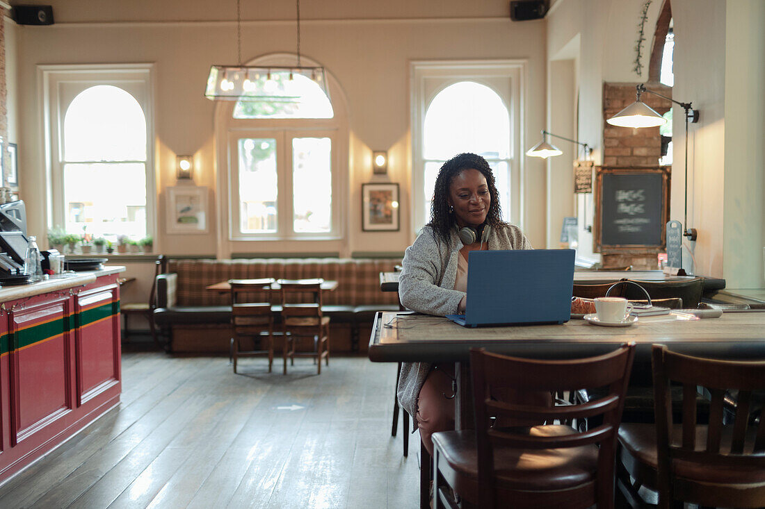 Businesswoman using a laptop at cafe table