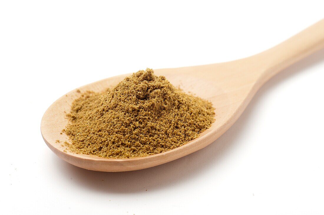 Ground cumin on a wooden spoon