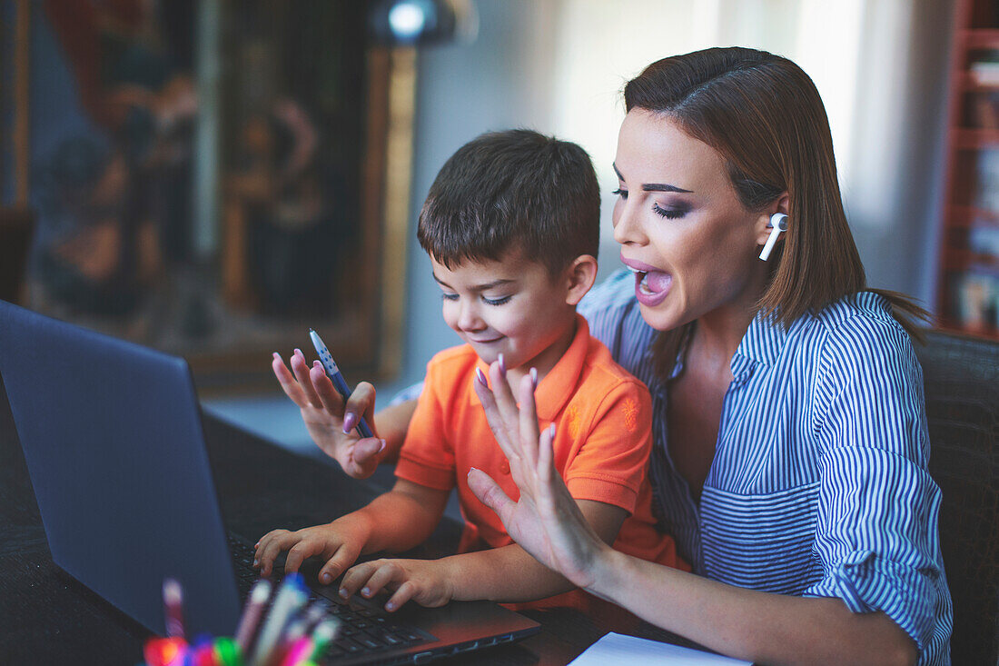 Mother stopping son typing on laptop